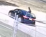 Camera photo of suspect entering black sedan on the street.